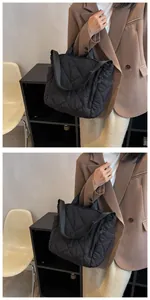 Detail of black quilted tote bag showing diamond stitching and detachable shoulder strap