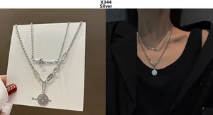 Detail of silver double layer necklace with coin pendant and unique textured chains
