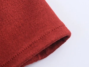 Detailed macro view of the dark red knitted fabric and precise double stitching