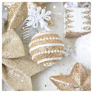 Macro detail of golden sequins and pearls on champagne Christmas tree ornaments