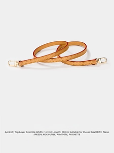 Macro shot of apricot top grain leather strap with gold buckle for luxury handbags