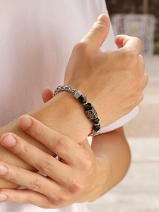 Men's punk bracelet with black faceted beads and vintage cross charm worn on wrist