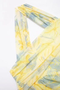Detail of yellow floral mesh bodysuit featuring halter neck cross design and sheer texture