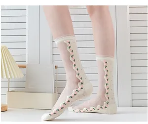 Detailed view of sheer white socks featuring delicate pink tulip embroidery and wavy edges