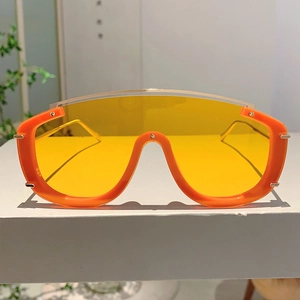 Close-up of futuristic orange oversized sunglasses with translucent yellow lenses