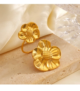 Detail of chunky gold floral stainless steel ring with petals on textured stone