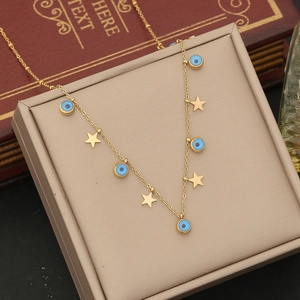 Detail of gold double-layer necklace with blue evil eye beads and stars on jewelry box