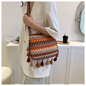 Detail of colorful woven bohemian shoulder bag with long tassels and patterned strap