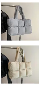 Detailed view of quilted puffer tote bags in grey and beige with soft padded textures