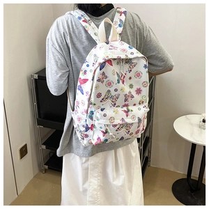Dettaglio dello zaino in tela bianca con stampe di farfalle e fiori colorati