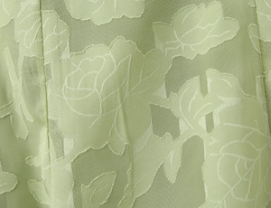 Nahaufnahme von hellbohnengrünem Kleiderstoff mit Rosenmuster-Jacquard-Textur