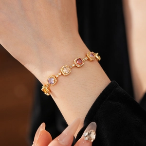 Macro detail of vintage gold bracelet with square colored gemstones and pavé crystals