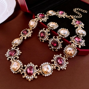 Detailed view of vintage gold-tone jewelry set with pink stones and sparkling crystals