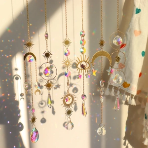 Close-up of crystal suncatchers with moon and star metal charms reflecting rainbow light