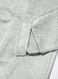 Close-up detail of light grey fabric texture and premium stitching on the pocket of the coat