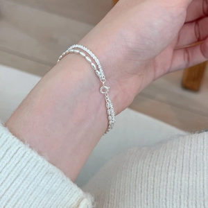 Double-layered 925 sterling silver star bracelet with delicate silver beads on wrist