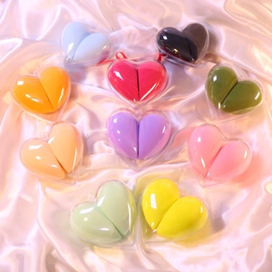 Colorful makeup sponges in heart-shaped boxes on pink silk background set of ten