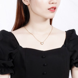 Élégant collier pendentif cœur doré avec incrustation coquillage porté par un mannequin