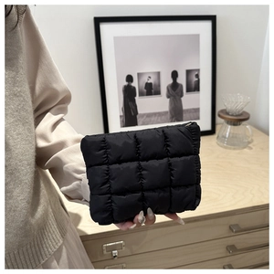 Close-up of black quilted down handbag texture and soft puffer fabric details