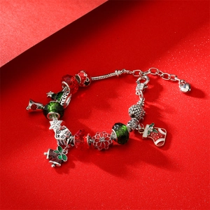 Bracelet de Noël avec perles bonhomme de neige, sapin et clochette sur fond rouge