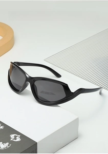 Close-up of sleek black wraparound sports sunglasses with dark grey lenses on white stand