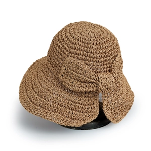 Détail de la texture d'un chapeau de paille marron avec large bord et nœud décoratif