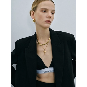 Collier avec pendentif croix en acier inoxydable plaqué or 18 carats porté par un mannequin