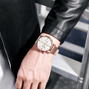 Close-up of Geneva men's rose gold watch with white dial and Milanese mesh band