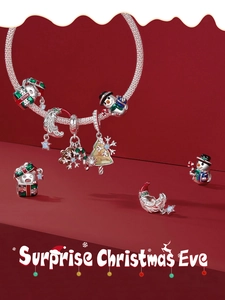 Detailed view of silver snake chain bracelet with colorful festive Christmas enamel charms
