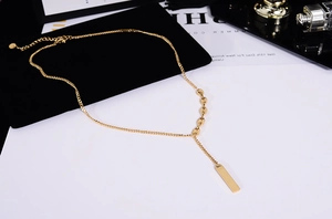 Detail of 18K gold-plated titanium steel necklace with bar pendant and bean links