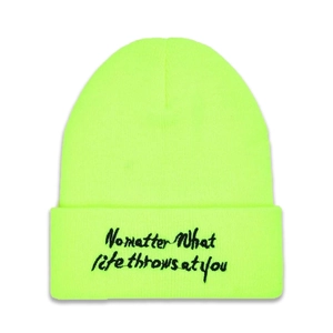 Detail of black embroidered No Matter text on neon green knitted beanie hat fold