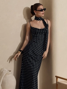 Detailed close-up of a black polka dot maxi dress with matching neck scarf accessory