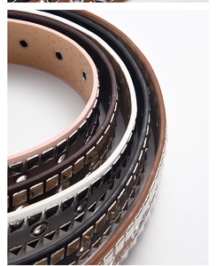 Close-up of punk style PU leather belts featuring square rivets and metal eyelets in four colors