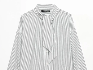 Detailed close-up of vertical striped poplin shirt with tie-neck and button closure
