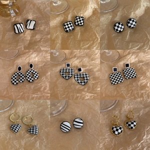 Collage of nine black and white geometric earrings with checkerboard and zebra patterns