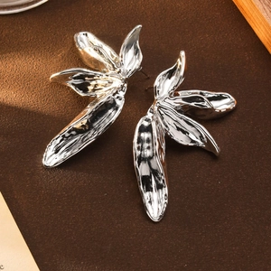 Vintage silver 3D floral leaf statement earrings with liquid metal texture on wood background