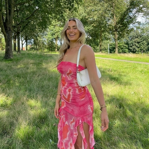Détail de la robe bustier à fleurs roses avec fente à volants et tissu en maille
