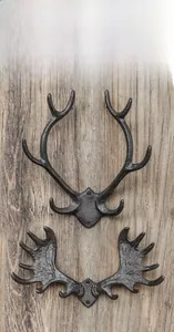 Close-up of vintage cast iron antler wall hooks with rustic texture and mounting holes