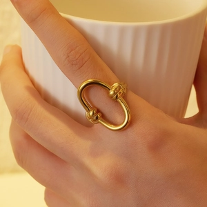 Close-up of a gold oval chain ring on finger featuring elegant pearl and zircon details