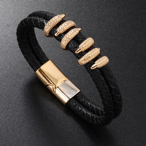 Detail of black braided leather bracelet featuring gold metal claw beads and magnetic clasp