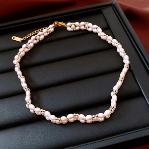 Détail d'un collier de perles blanches plaqué or 18 carats sur un plateau à bijoux
