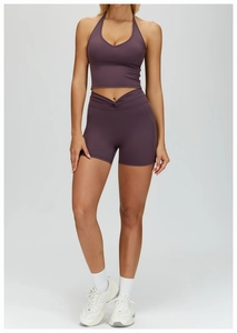 Detail of deep purple yoga set showing V-neck crop top and crossover waist shorts