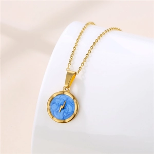 Detailed view of a gold disc pendant with blue enamel and a lightning bolt symbol