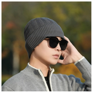 Close-up of grey knit beanie fabric showing thick ribbed texture and warm folded brim