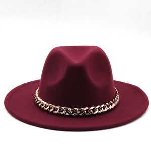 Detail of burgundy wool fedora hat featuring a stylish thick gold metal chain band