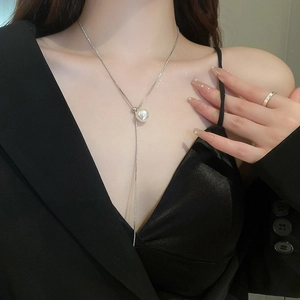 Detail of elegant silver snake chain necklace with pearl pendant on model neck
