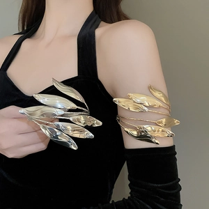 Detailed close-up of multilayer gold and silver leaf arm cuffs worn on upper arm