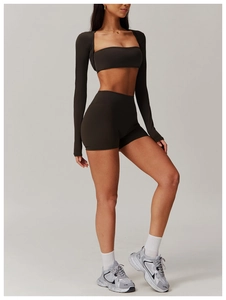 Detailed close-up of dark brown three-piece yoga set with shrug, sports bra and shorts