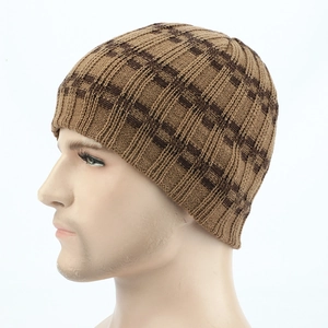 Detail of winter knitted beanie featuring brown checkered pattern and warm thick texture