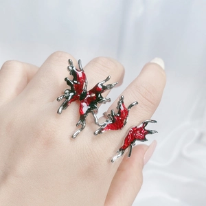 Detail view of butterfly open rings set with red enamel wings and fluid metal texture